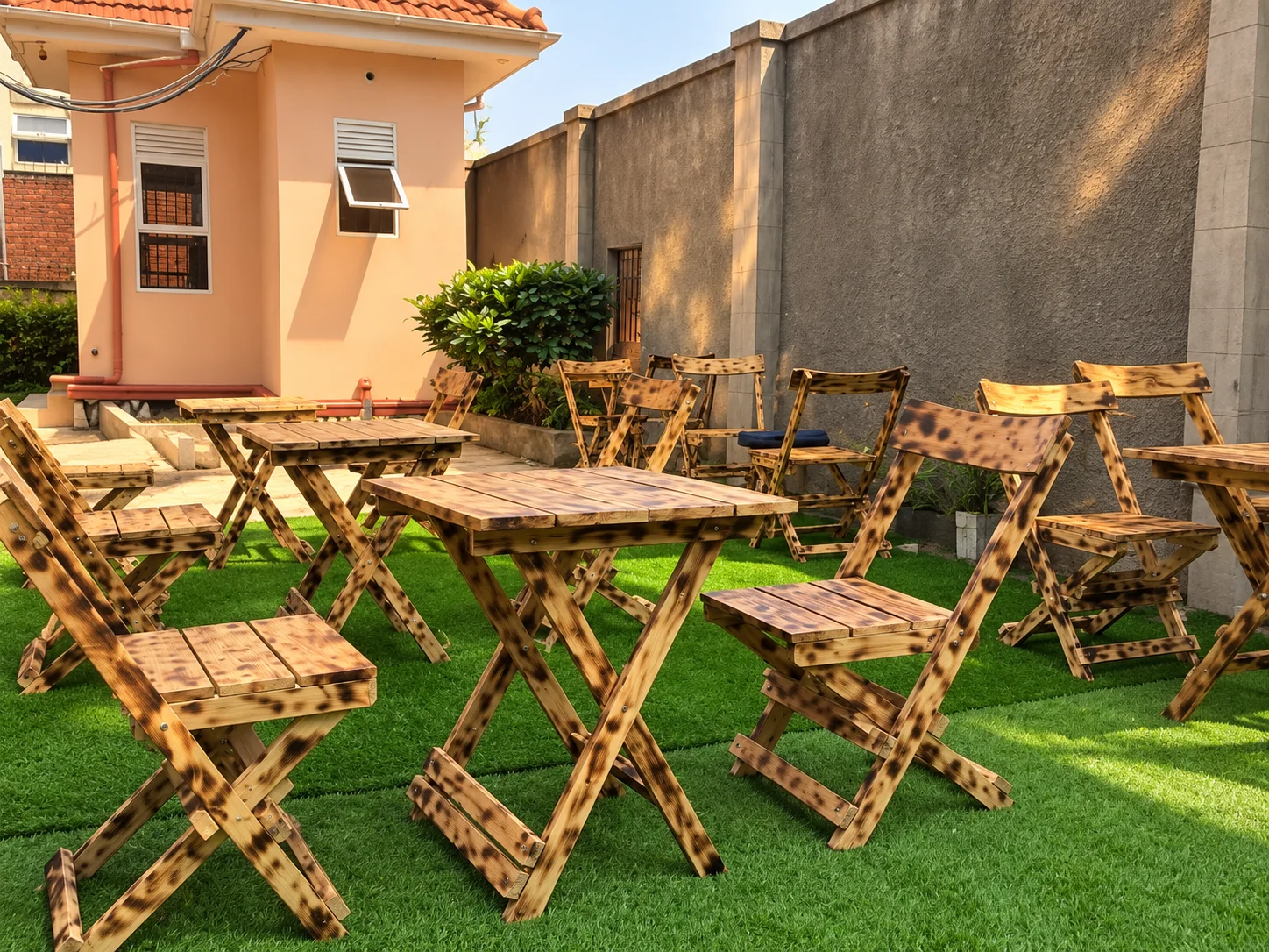 Rustic wooden tables and chairs in Laboss Motel’s outdoor lounge